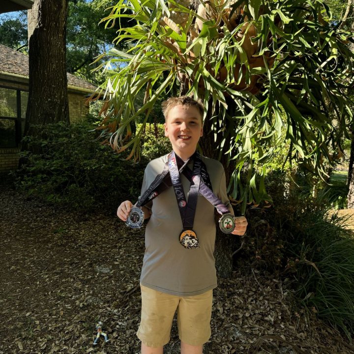 US Road Running race day photo with runners, walkers, finisher medals, and race staff