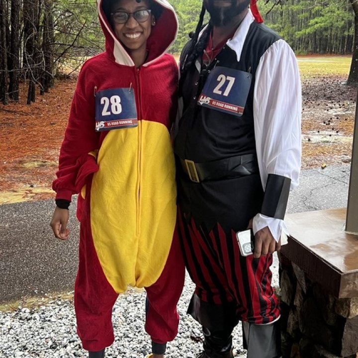 US Road Running race day photo with runners, walkers, finisher medals, and race staff