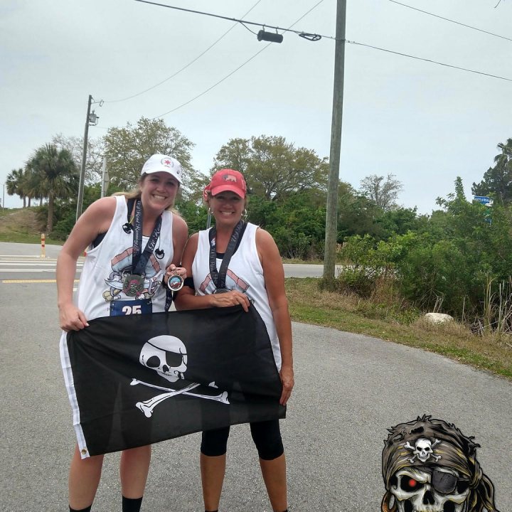 US Road Running race day photo with runners, walkers, finisher medals, and race staff