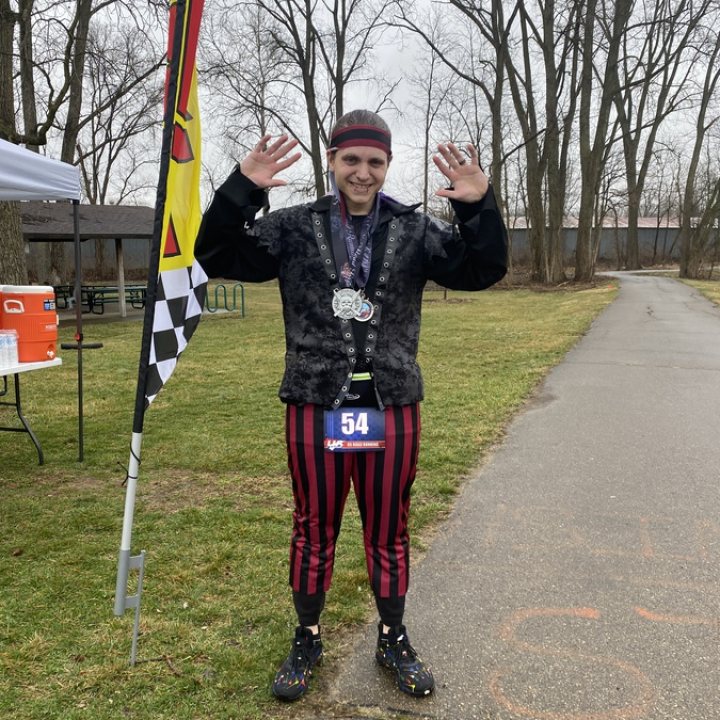 US Road Running race day photo with runners, walkers, finisher medals, and race staff