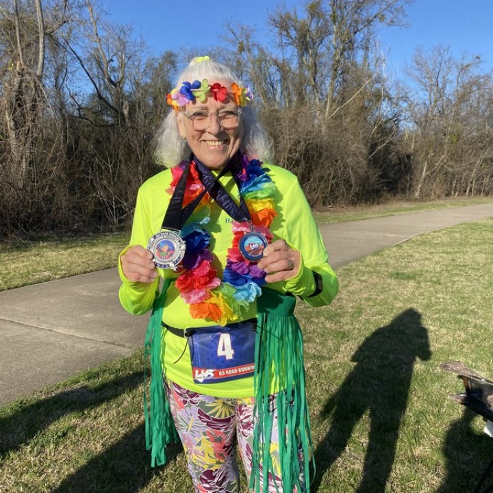 US Road Running race day photo with runners, walkers, finisher medals, and race staff