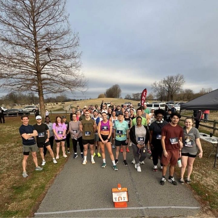 US Road Running race day photo with runners, walkers, finisher medals, and race staff