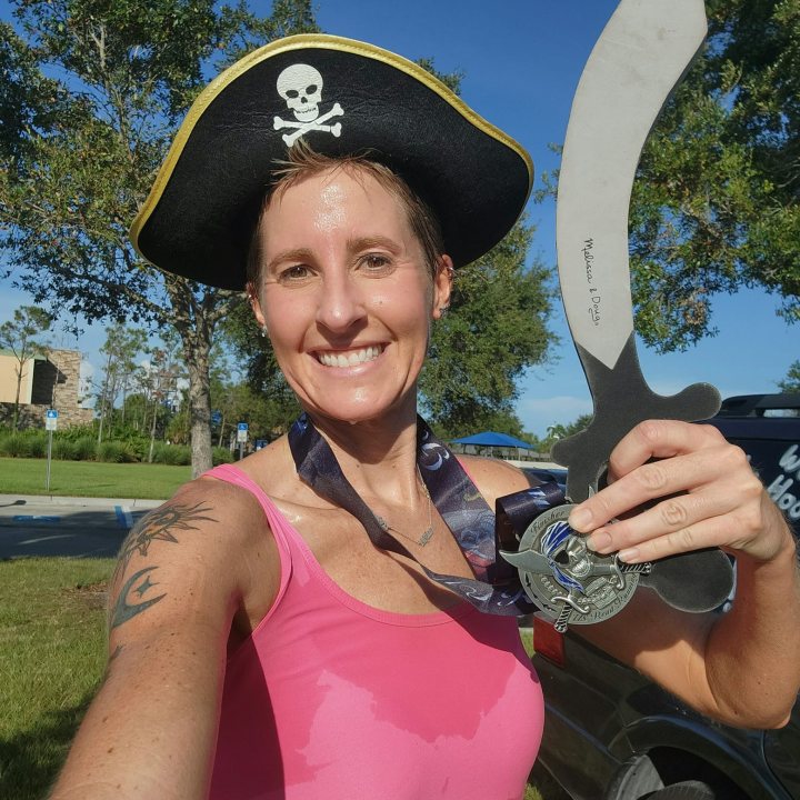 US Road Running race day photo with runners, walkers, finisher medals, and race staff
