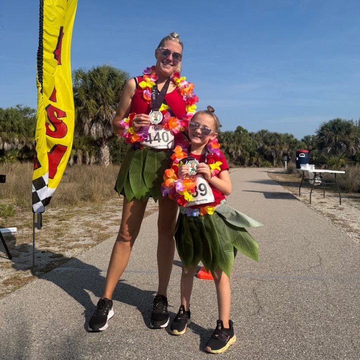 US Road Running race day photo with runners, walkers, finisher medals, and race staff