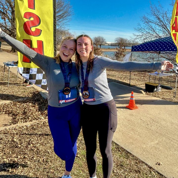 US Road Running race day photo with runners, walkers, finisher medals, and race staff