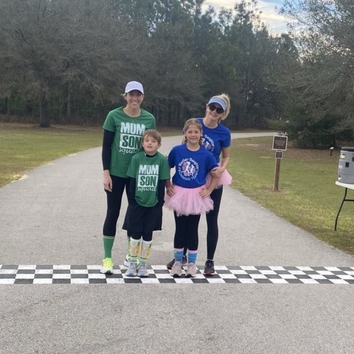 US Road Running race day photo with runners, walkers, finisher medals, and race staff