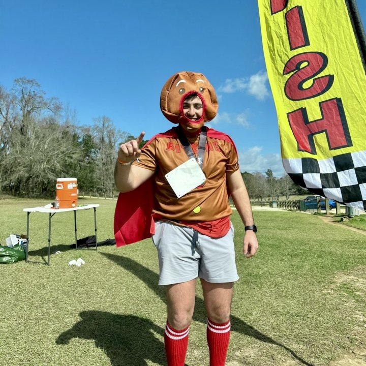 US Road Running race day photo with runners, walkers, finisher medals, and race staff