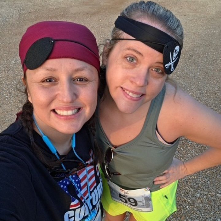 US Road Running race day photo with runners, walkers, finisher medals, and race staff