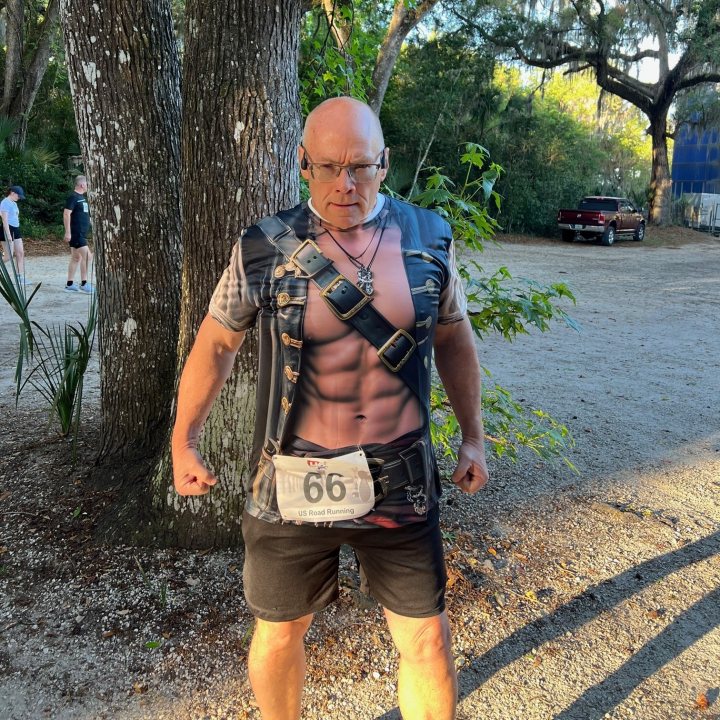 US Road Running race day photo with runners, walkers, finisher medals, and race staff