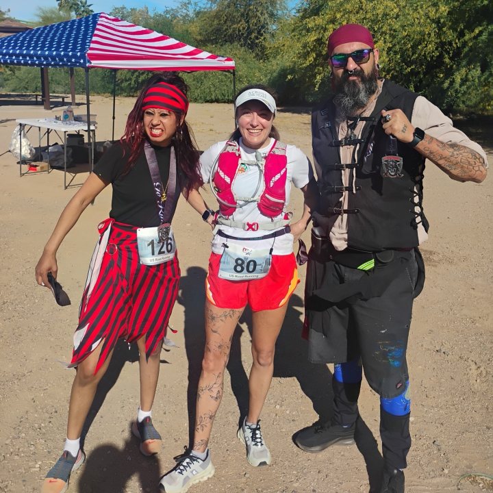 US Road Running race day photo with runners, walkers, finisher medals, and race staff