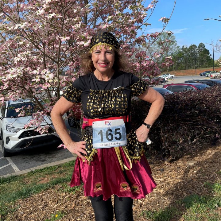 US Road Running race day photo with runners, walkers, finisher medals, and race staff