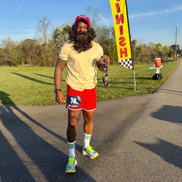 US Road Running race day photo with runners, walkers, finisher medals, and race staff