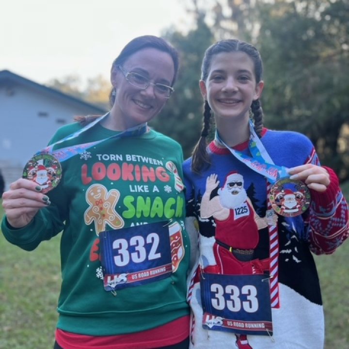 US Road Running race day photo with runners, walkers, finisher medals, and race staff