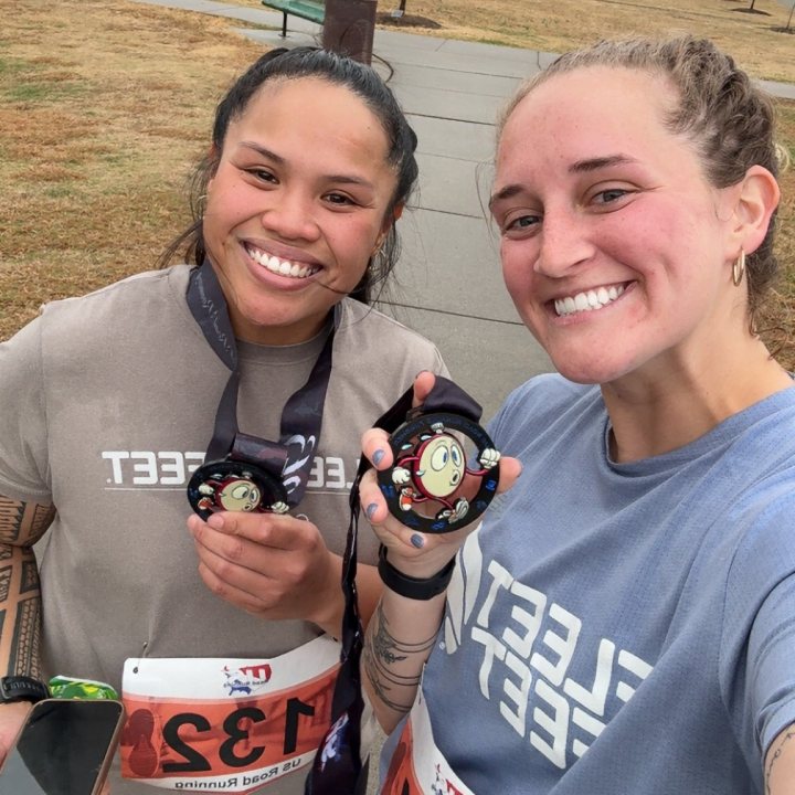 US Road Running race day photo with runners, walkers, finisher medals, and race staff