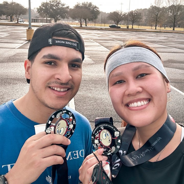 US Road Running race day photo with runners, walkers, finisher medals, and race staff
