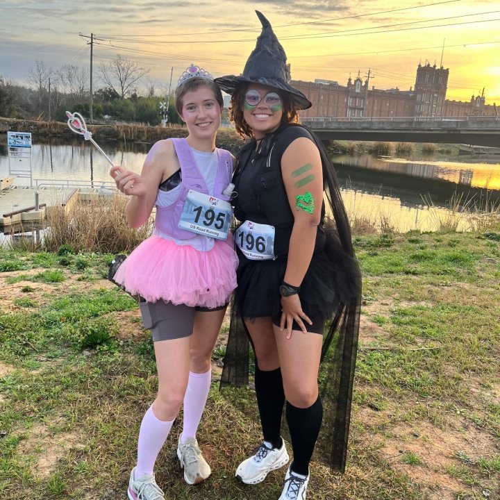 US Road Running race day photo with runners, walkers, finisher medals, and race staff